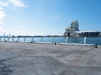 a view of the water with sea lion statue in background with clouds above and a body of water