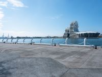 a view of the water with sea lion statue in background with clouds above and a body of water