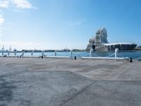 a view of the water with sea lion statue in background with clouds above and a body of water