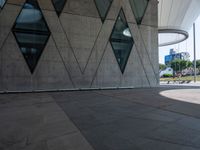 the skateboarder is practicing his moves in front of a building with geometric windows