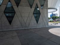 the skateboarder is practicing his moves in front of a building with geometric windows