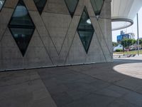 the skateboarder is practicing his moves in front of a building with geometric windows