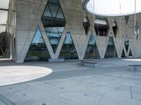 the skateboarder is practicing his moves in front of a building with geometric windows