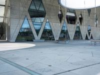 the skateboarder is practicing his moves in front of a building with geometric windows