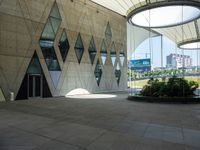 there is a building with two buildings in it and a circular planter next to a walkway