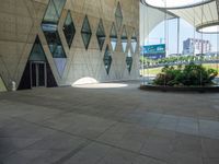 there is a building with two buildings in it and a circular planter next to a walkway