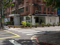 a street corner with a pedestrian crossing and a sign on the corner of it in front of a brick building