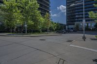 an empty empty parking lot is surrounded by tall buildings and trees in a city setting