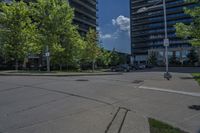 an empty empty parking lot is surrounded by tall buildings and trees in a city setting