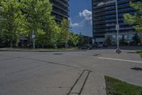 an empty empty parking lot is surrounded by tall buildings and trees in a city setting