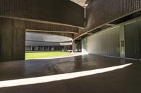 empty open concrete floor in an atrium area with grass on the lawn, and concrete pillars