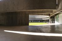 empty open concrete floor in an atrium area with grass on the lawn, and concrete pillars