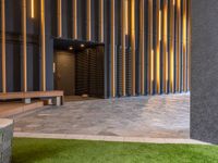 a walkway leading up to a wooden wall next to a cement area with floor tiles