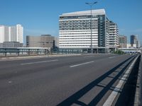 the highway and bridge leading to a city in japan and has tall buildings and blue skies