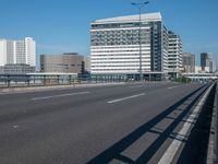 the highway and bridge leading to a city in japan and has tall buildings and blue skies