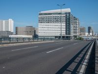 the highway and bridge leading to a city in japan and has tall buildings and blue skies