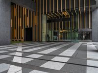 a walkway leading up to a wooden wall next to a cement area with floor tiles