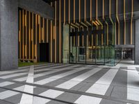 a walkway leading up to a wooden wall next to a cement area with floor tiles