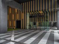 a walkway leading up to a wooden wall next to a cement area with floor tiles