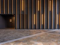 a walkway leading up to a wooden wall next to a cement area with floor tiles