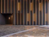 a walkway leading up to a wooden wall next to a cement area with floor tiles