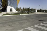 a man riding his bike down the road on a sunny day with a large building in the background