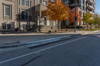 a street intersection with parking spaces and a stop sign, the sidewalk is empty, and one of the sides is empty