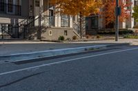 a street intersection with parking spaces and a stop sign, the sidewalk is empty, and one of the sides is empty