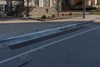 a street intersection with parking spaces and a stop sign, the sidewalk is empty, and one of the sides is empty