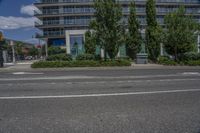 a building with two tall trees in front of it on a street corner with buildings behind