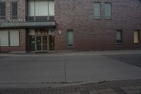 a building with windows that say the hill theatre is open on a street corner next to a fire hydrant