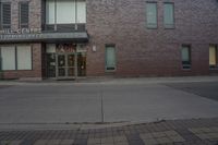 a building with windows that say the hill theatre is open on a street corner next to a fire hydrant