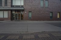 a building with windows that say the hill theatre is open on a street corner next to a fire hydrant