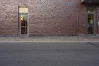 a very red brick building with an entrance way that goes down the front street to the sidewalk