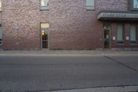 a very red brick building with an entrance way that goes down the front street to the sidewalk