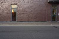 a very red brick building with an entrance way that goes down the front street to the sidewalk