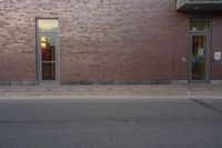 a very red brick building with an entrance way that goes down the front street to the sidewalk