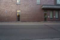 a very red brick building with an entrance way that goes down the front street to the sidewalk