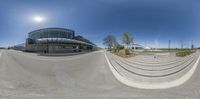 a small, curved circular photo in front of a building with stairs and grass area near the parking lot