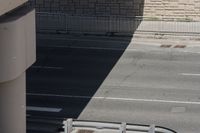 a bridge over a street that has a bench in the middle of it and a sidewalk underneath it