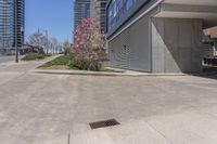 the sidewalk near an industrial building with a bench in the corner of it and a bench on a street outside