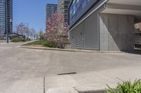 the sidewalk near an industrial building with a bench in the corner of it and a bench on a street outside