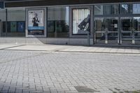 a person sitting at the bench in front of a mall that is empty of people