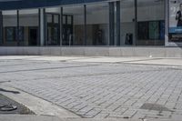 a person sitting at the bench in front of a mall that is empty of people