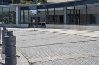 a person sitting at the bench in front of a mall that is empty of people