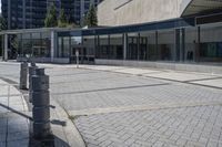 a person sitting at the bench in front of a mall that is empty of people