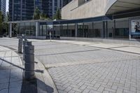 a person sitting at the bench in front of a mall that is empty of people