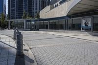 a person sitting at the bench in front of a mall that is empty of people