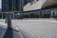 a person sitting at the bench in front of a mall that is empty of people