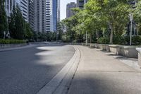 a car driving down an empty street lined with tall buildings and trees in the background